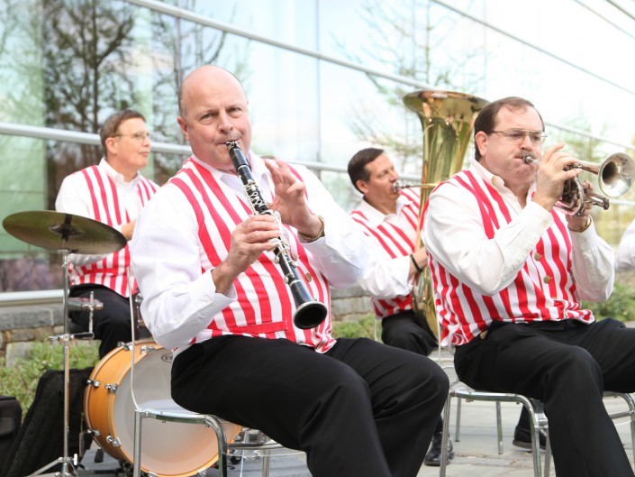 Man in red and white striped vest plays mouth instrument