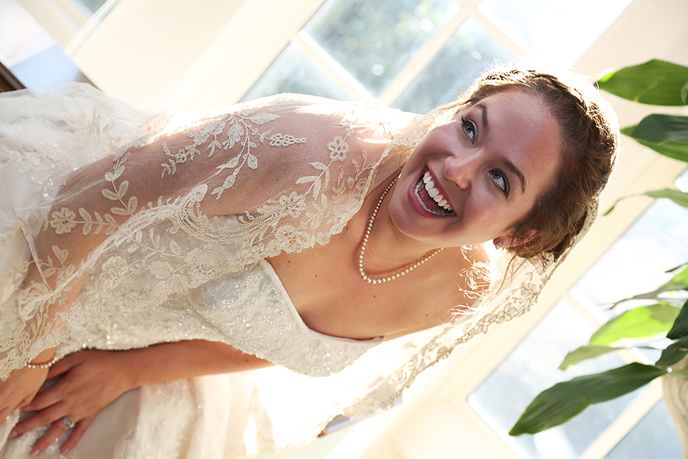 A woman in a wedding dress, radiating joy with a captivating smile, exudes happiness on her special day.