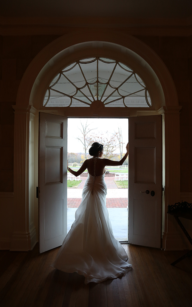A beautiful bride standing in an open doorway, ready to start her new life.