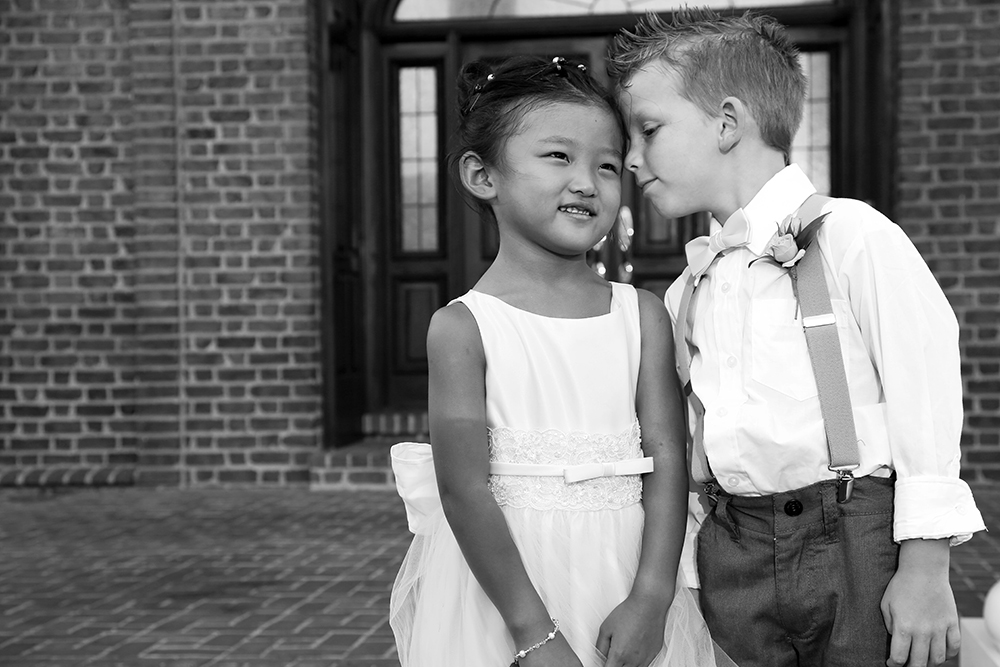 Boy and girl standing outside a church, symbolizing innocence and faith in a serene setting.