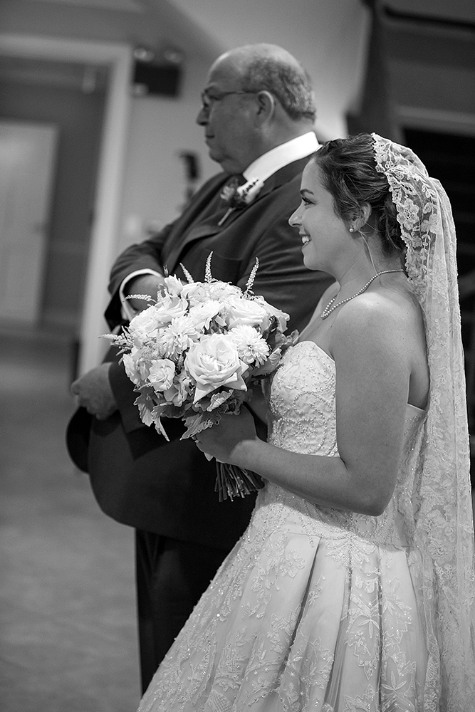 A bride and her father gracefully walk down the aisle, symbolizing a cherished moment of love and unity.