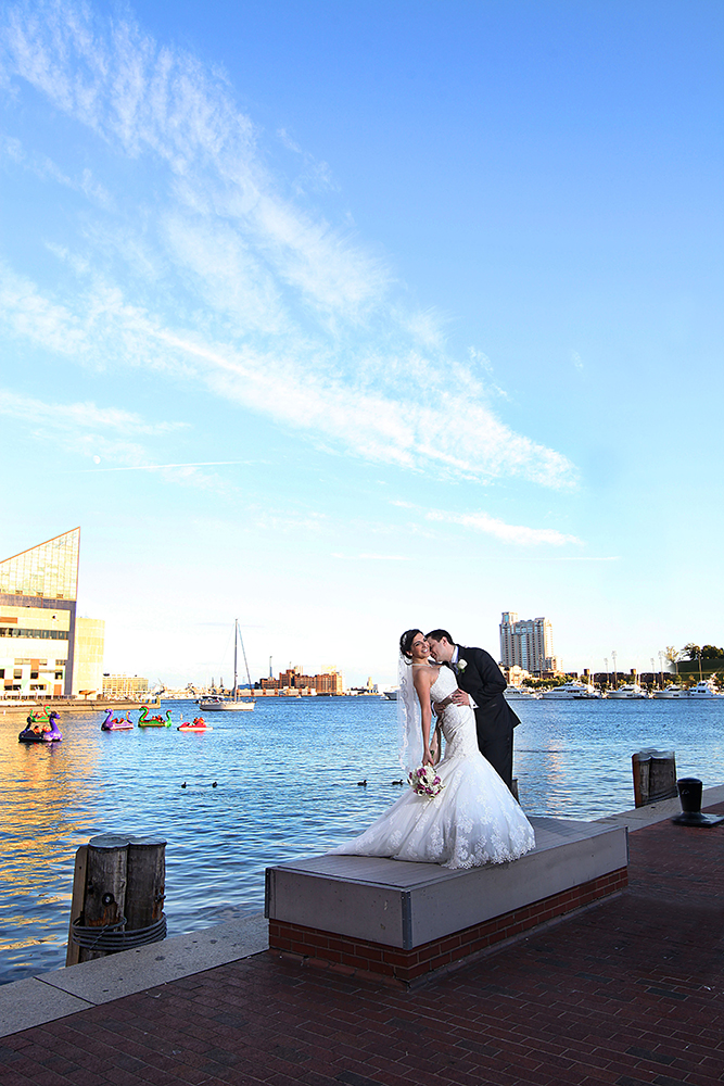 Newlyweds kiss on bench by water, celebrating love and new journey