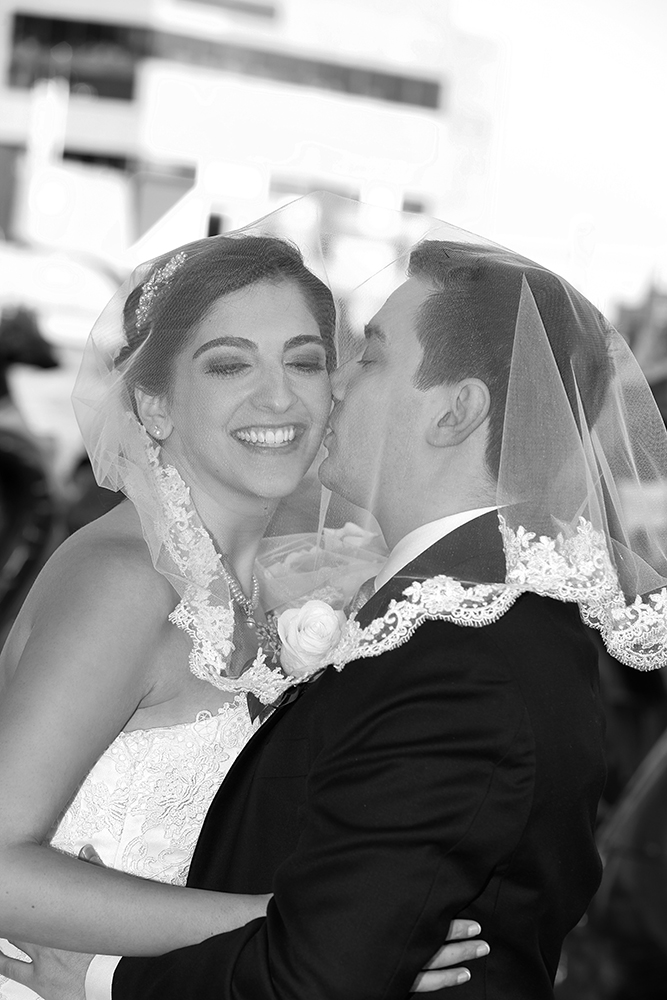 Newlyweds share a kiss in front of their loved ones on their special day.