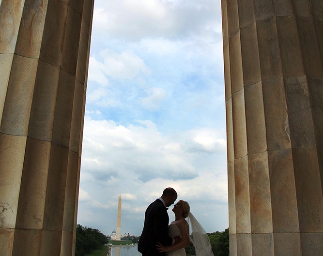 Newlyweds kiss at Lincoln Memorial, symbolizing love on their special day