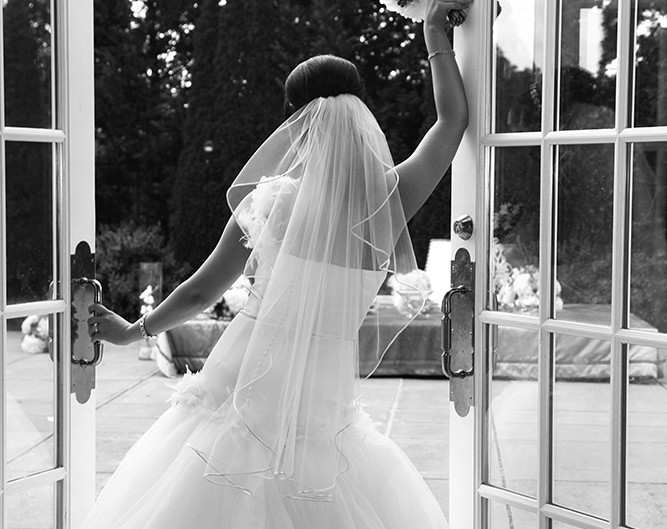 Beautiful bride poised in front of an open door, ready for a new journey.