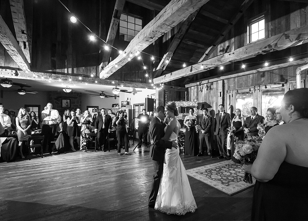 Newlyweds gracefully dance, celebrating love surrounded by loved ones at wedding reception