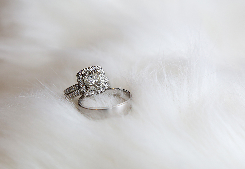 Wedding rings displayed on a white fur rug.