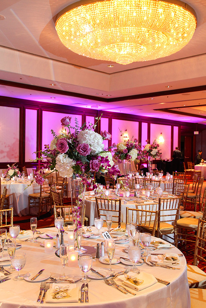 Weddinag reception set up in a spacious room with tables and chairs.