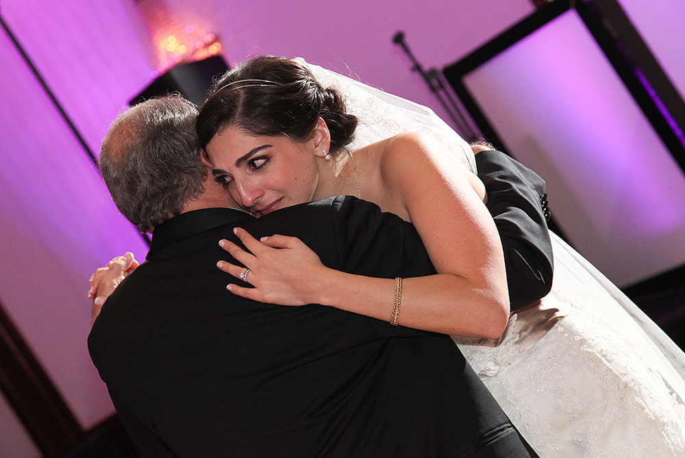Bride embraces father during their first dance.