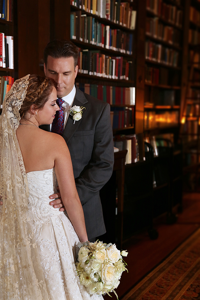 Bride and groom captured in front of a stunning library backdrop.