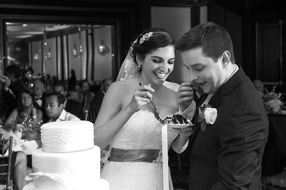 Bride and groom share elegant wedding cake, symbolizing unity amidst love and happiness