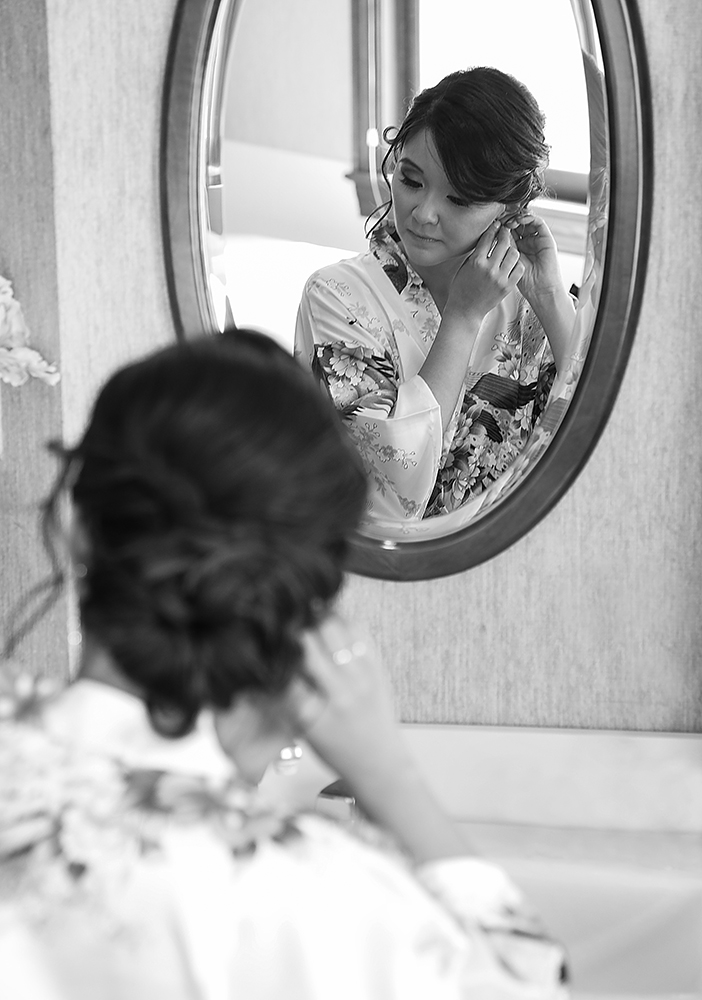 Woman in robe admiring herself in mirror.