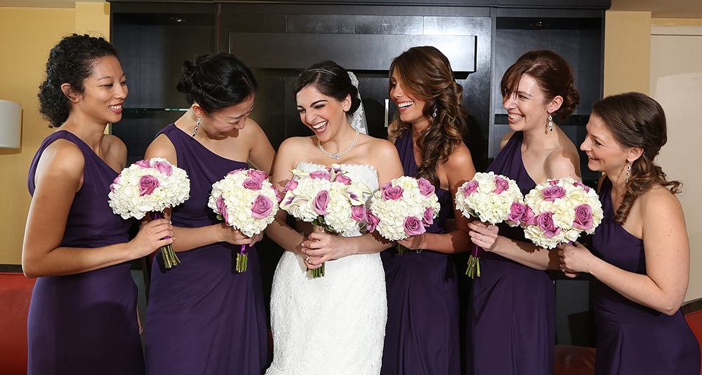 A captivating image showcasing a bride and her bridesmaids elegantly dressed in stunning purple attire.