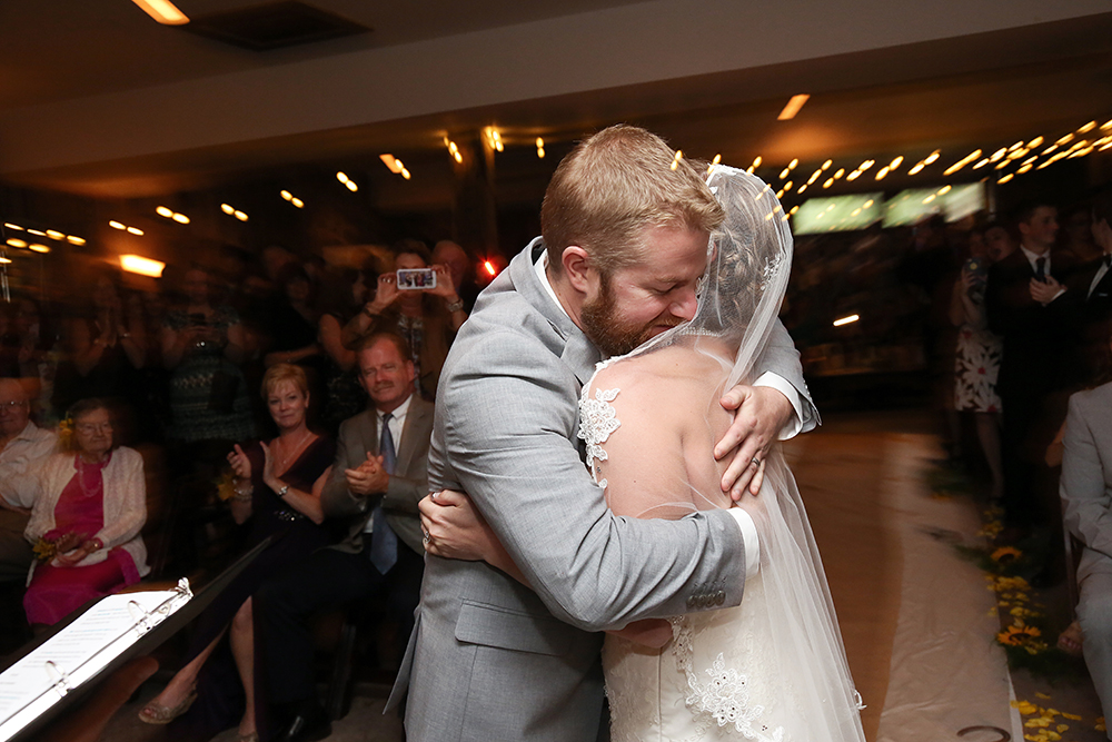Bride and groom embrace joyfully, symbolizing love and commitment
