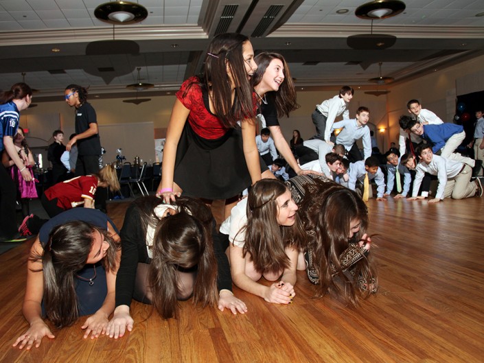 A group of young girls sitting on the floor, actively engaged in an activity.
