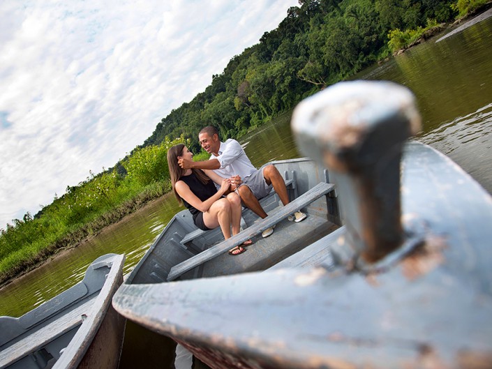 Serene scene of a couple in a boat on a calm lake, surrounded by nature's beauty.