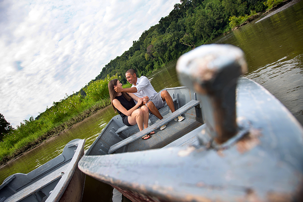 Serene scene of a couple in a boat on a calm lake, surrounded by nature's beauty.