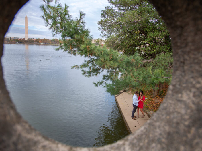 Engaged couple and the DC monument showing from one of the holes of the bridge. Tidal Basin Washington DC