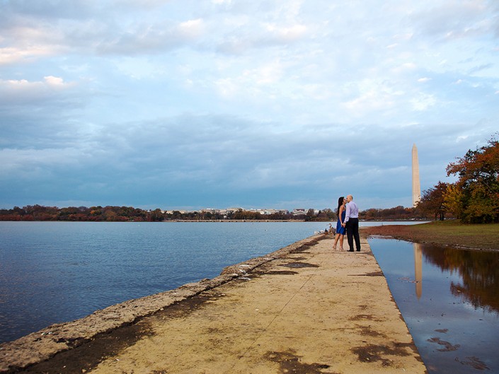 A couple standing on a dock, gazing at the water's serene beauty