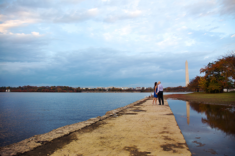 A couple standing on a dock, gazing at the water's serene beauty