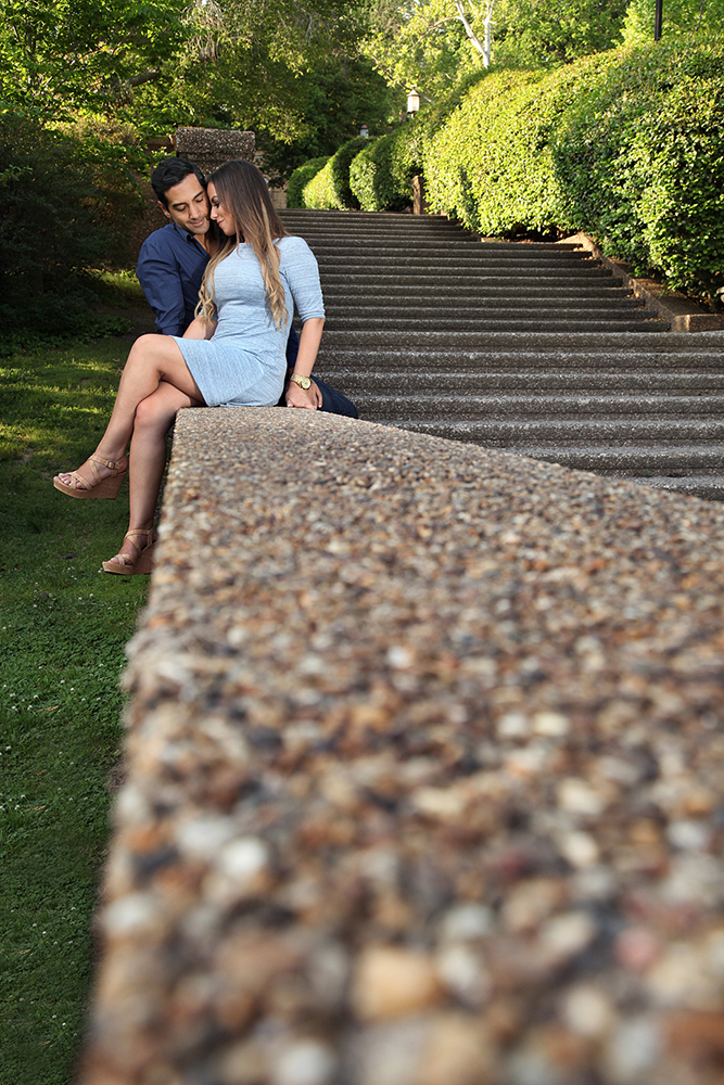 A romantic couple taking a break on a stone wall, surrounded by the beauty of nature.