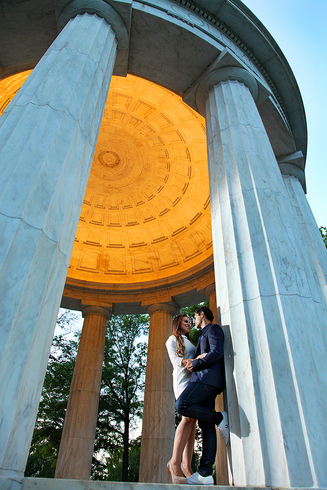 A romantic couple framed by a massive stone arch.