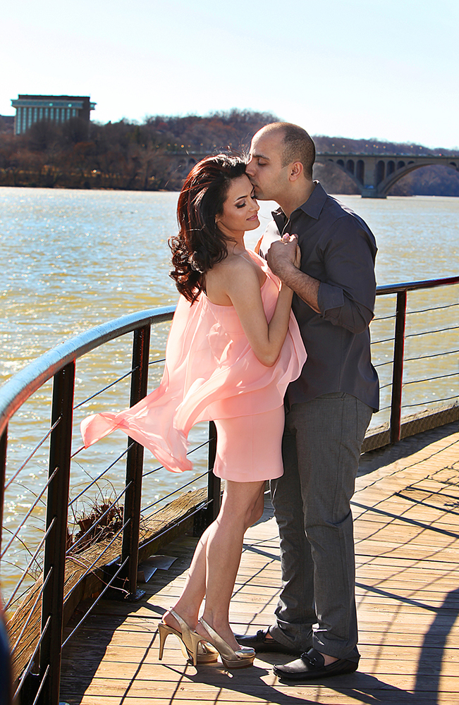 A couple stands on a dock, enjoying the serene waterside view.