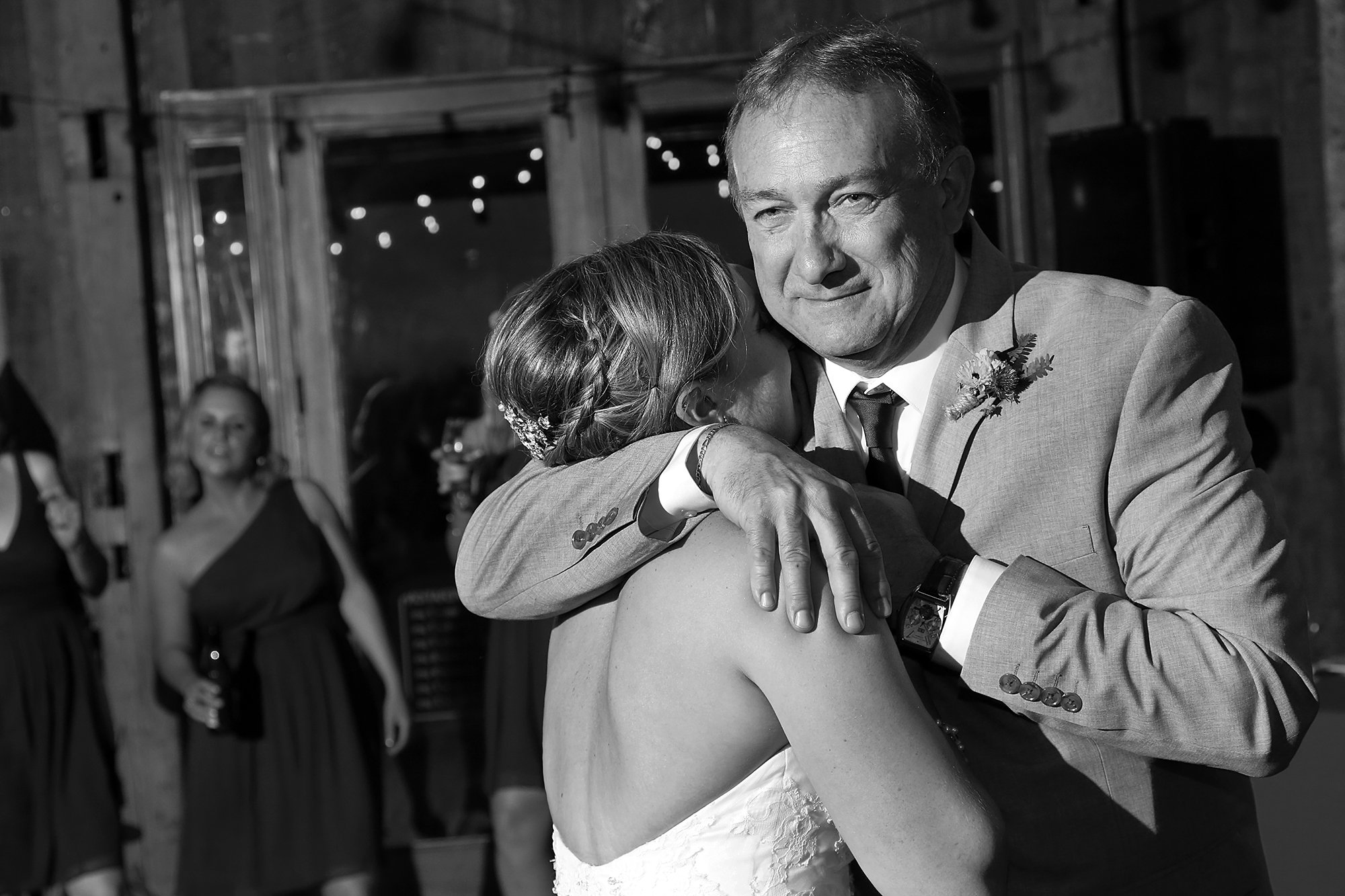 Father embraces daughter at wedding reception.