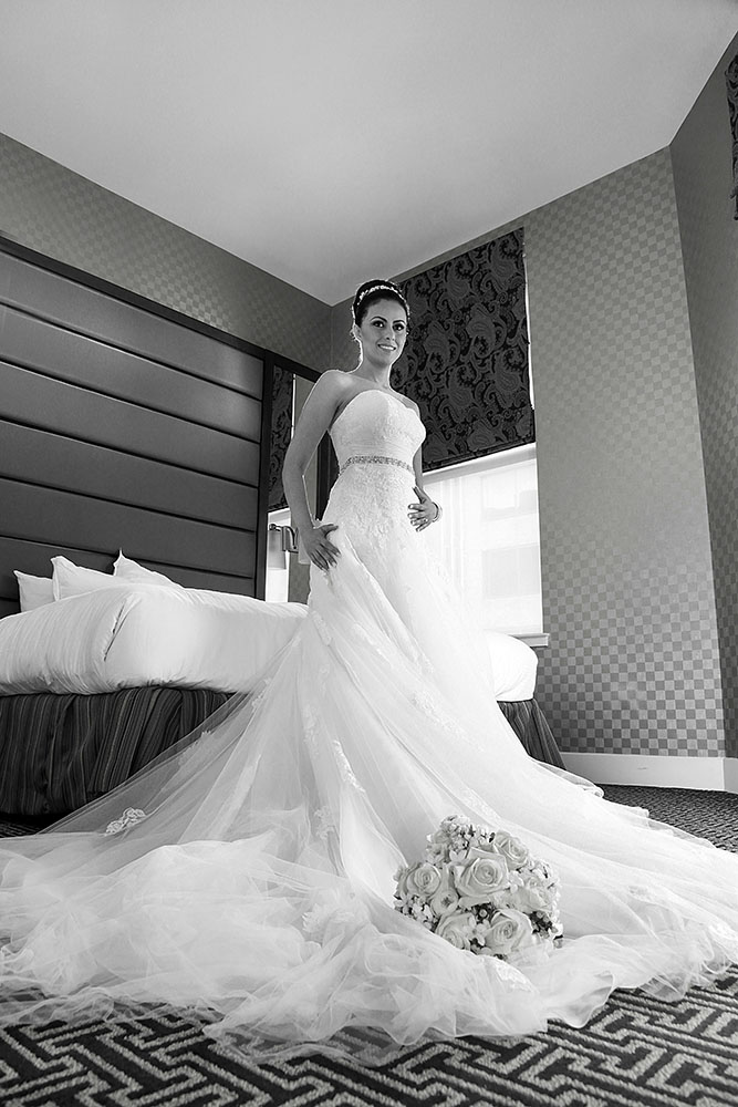 A beautiful bride in her wedding gown posing in a hotel room.