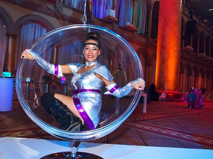 A woman sitting inside a transparent ball placed on a table