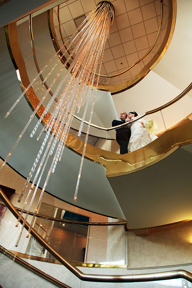Newlyweds on building stairs, radiating joy and love.
