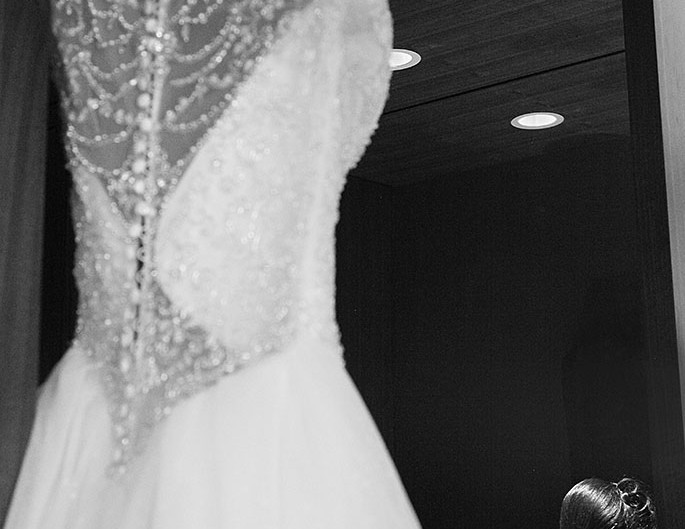 Bride's dress hanging in mirror.
