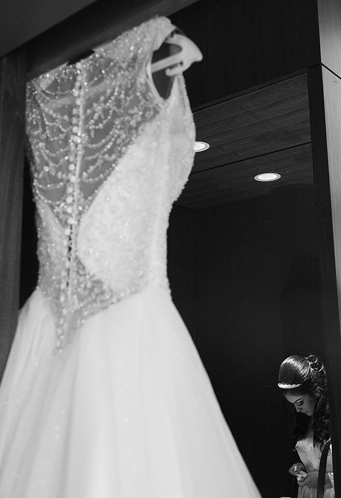 Bride's dress hanging in mirror.