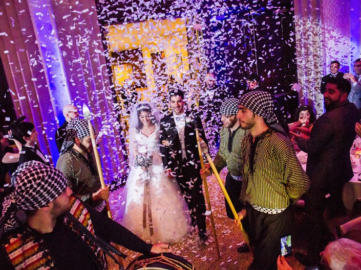 A joyful bride and groom amidst a shower of colorful confetti on their special day.