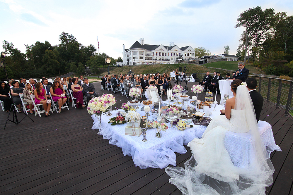 Persian wedding ceremony on wooden deck with crowd. Trump National Golf Club, Virginia