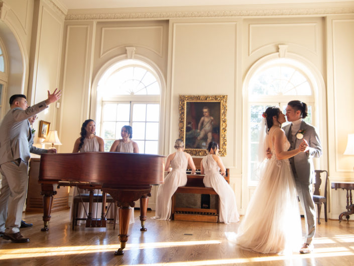 A couple joyfully dances at the center of a room, celebrating their wedding day with elegance and love.