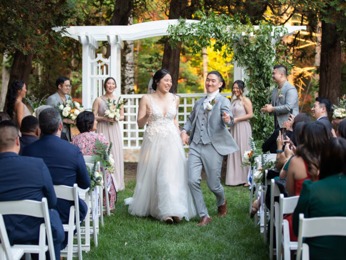 A wedding ceremony at the winery, a scene where love and joy intertwine against the backdrop of picturesque vineyards and the winery's rustic charm.