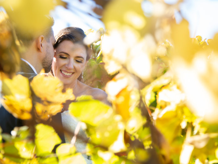 A couple is wrapped in an embrace within the lush vineyards, celebrating their unity on their wedding day, with nature's splendor as their backdrop.