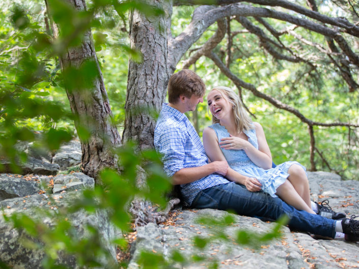 Couple seated on a rock in a serene woodland setting