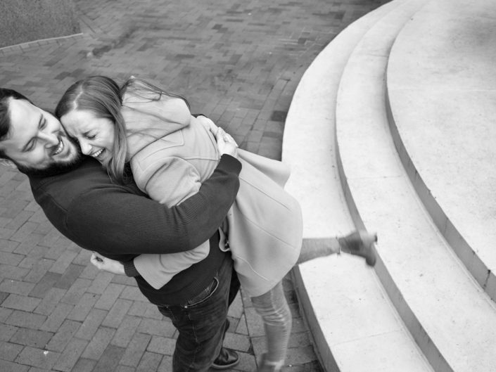 Affectionate couple hugging on steps.