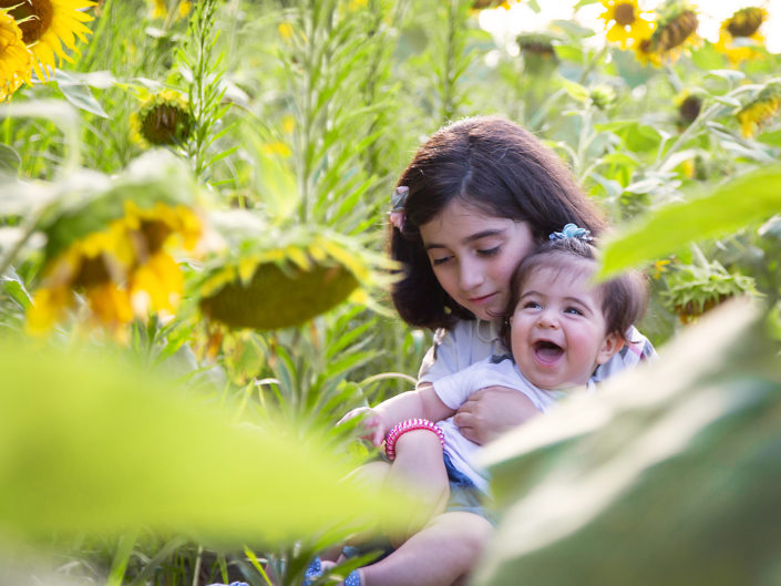 Woman and child in sunflower field, basking in nature's glow.