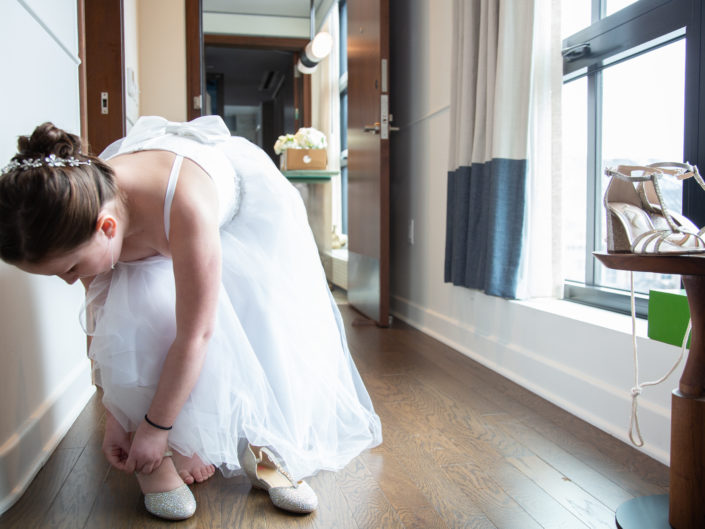 Bride putting on her wedding shoes, completing her ensemble.