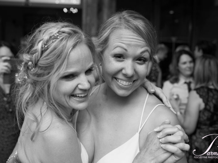Joyful embrace: two women at elegant wedding.
