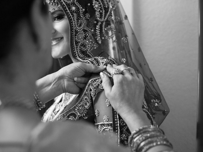 Woman in Indian wedding dress adjusting her veil
