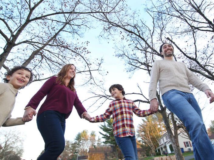 A family holding hands in a park.