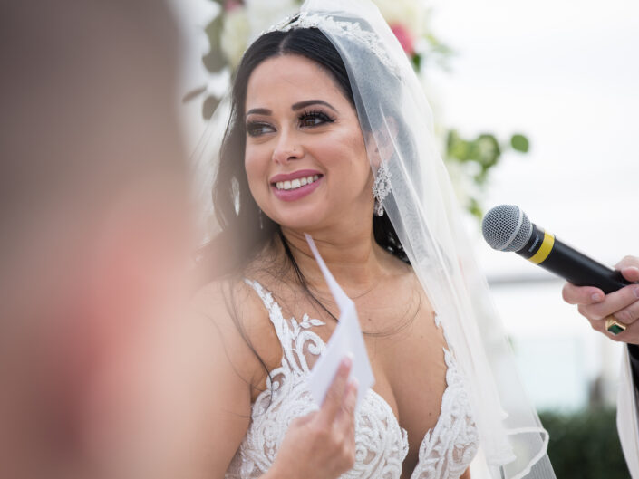A bride is speaking into a microphone during her wedding ceremony.